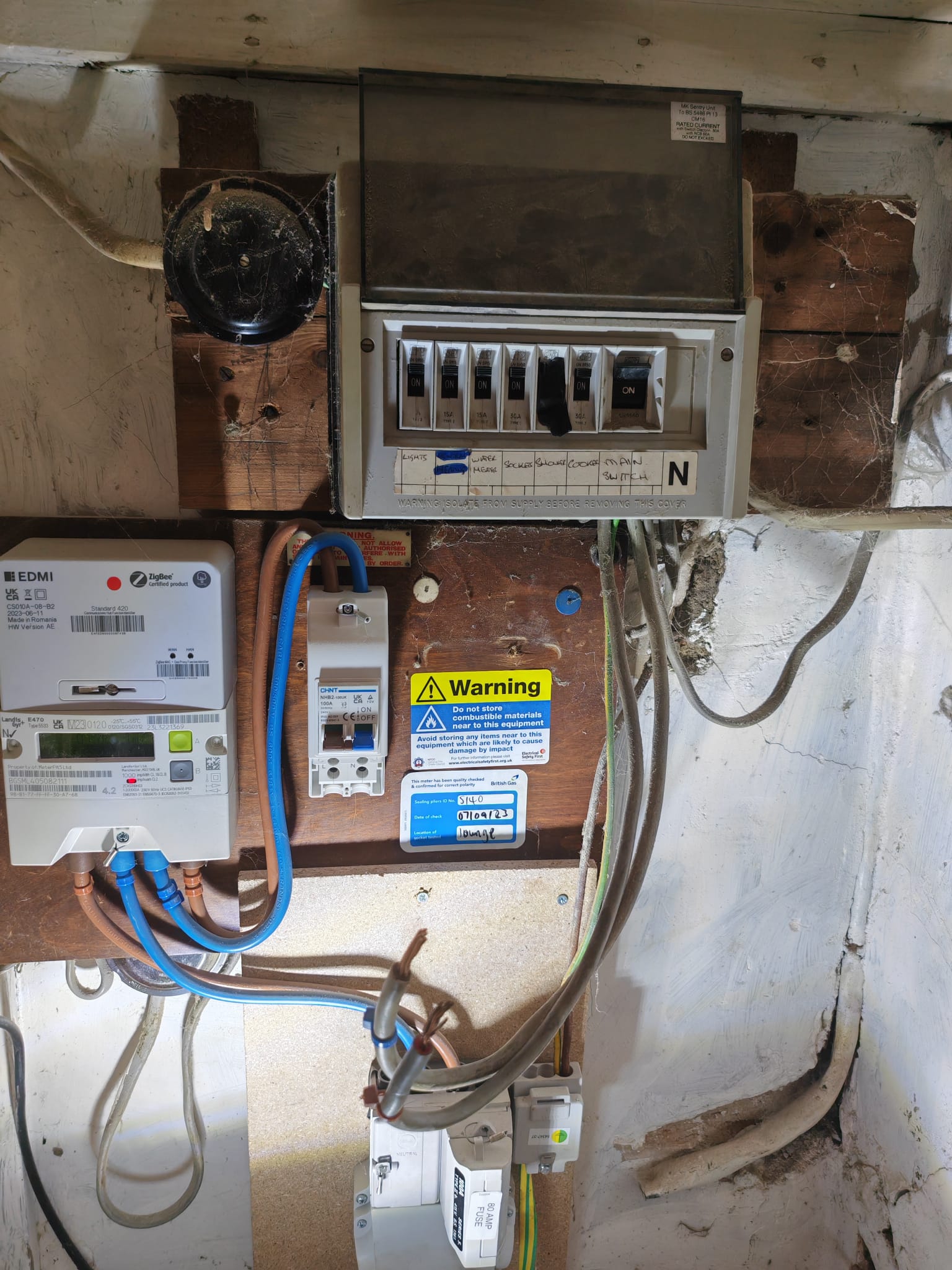 Old rewireable fuse board and electricity meter before replacement