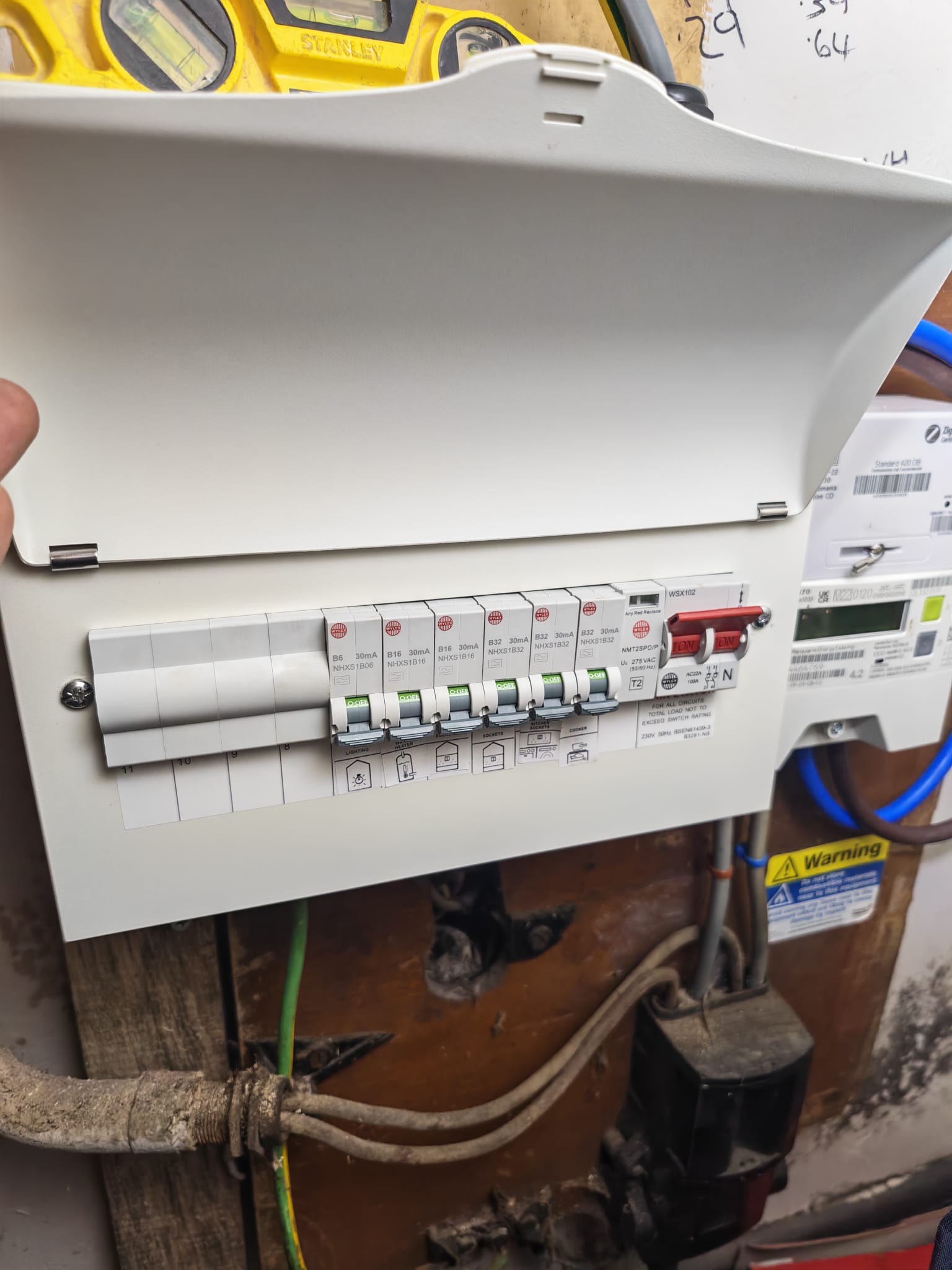 Finished Wylex consumer unit with circuits labelled — lighting, water heater, sockets, kitchen sockets, cooker