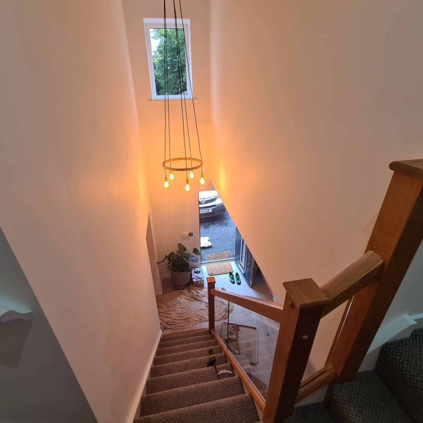 Completed chandelier in stairwell — warm lighting