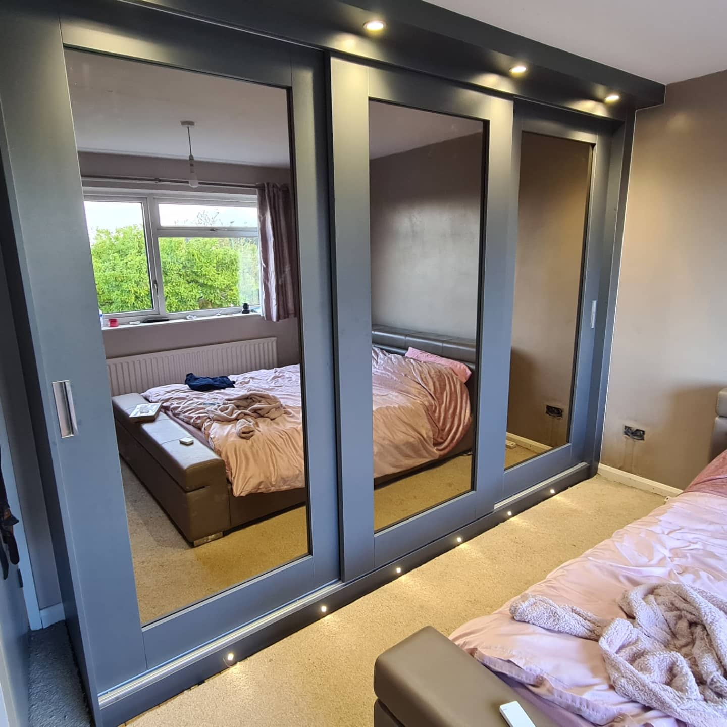 Bedroom with LED-lit fitted wardrobes